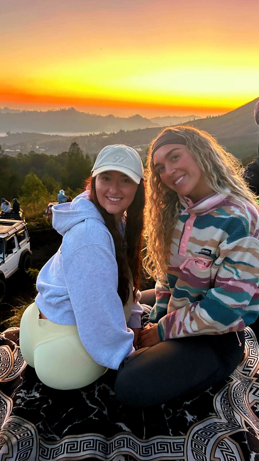 Two friends watching the sunrise over Mount Batur